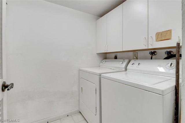 clothes washing area featuring hookup for a washing machine, washing machine and dryer, light tile floors, and cabinets