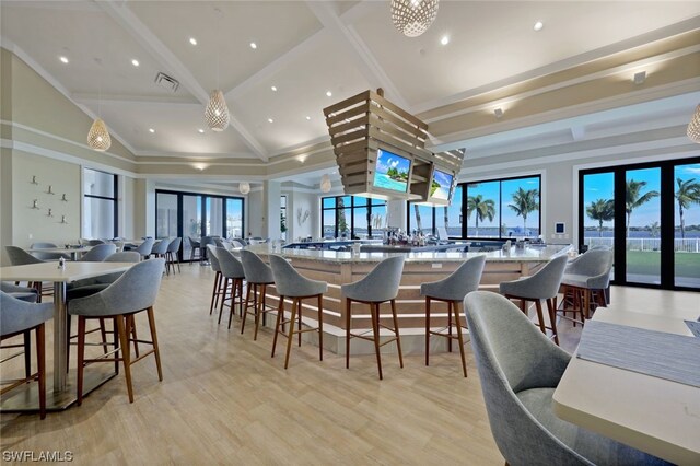 dining area with a healthy amount of sunlight, light hardwood / wood-style floors, lofted ceiling, and french doors