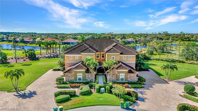 mediterranean / spanish home with a front lawn and a water view