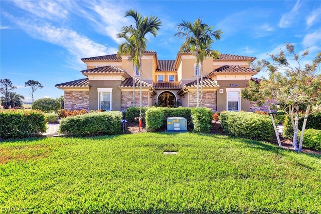 mediterranean / spanish-style house with a front yard