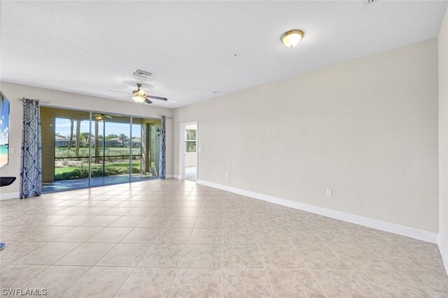 empty room with ceiling fan and light tile patterned floors