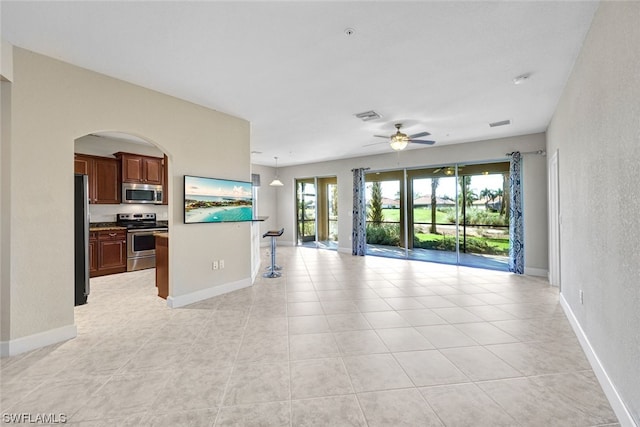 unfurnished living room featuring light tile patterned flooring and ceiling fan