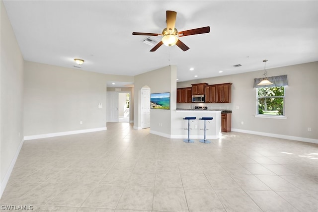 unfurnished living room featuring light tile patterned floors and ceiling fan