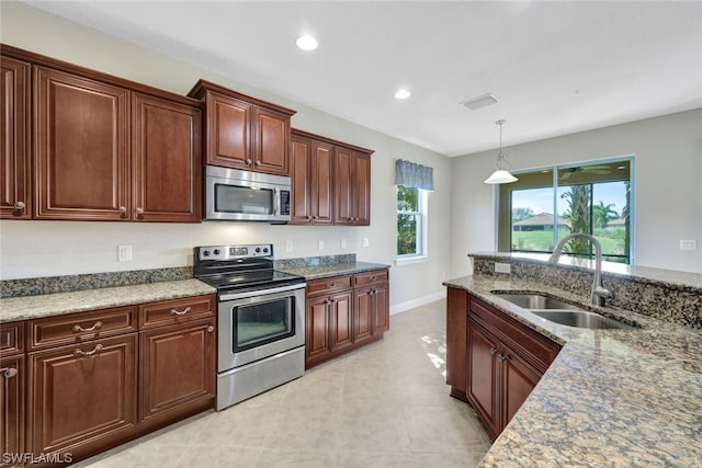 kitchen featuring light tile patterned floors, appliances with stainless steel finishes, sink, and pendant lighting