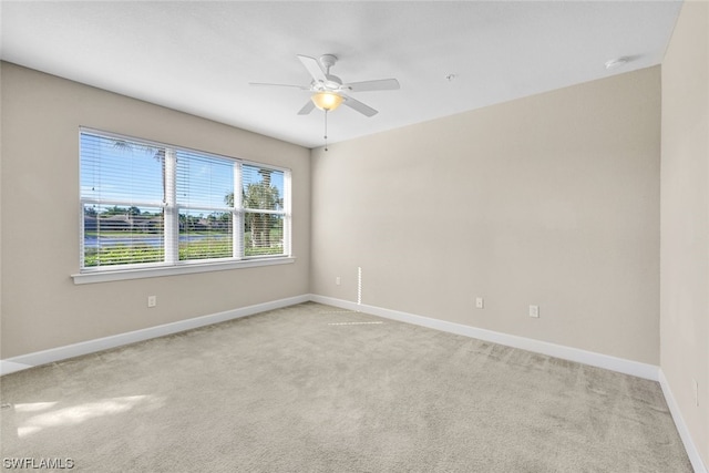 empty room featuring ceiling fan and light colored carpet