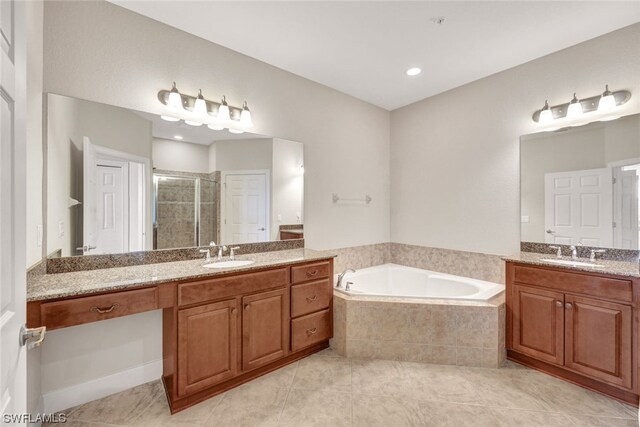 bathroom with dual vanity, tiled tub, and tile patterned floors