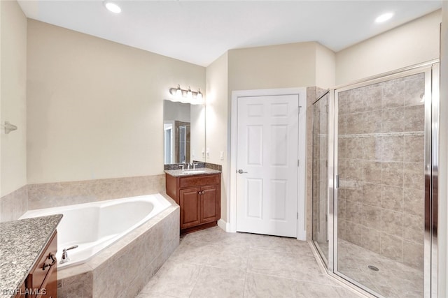 bathroom with shower with separate bathtub, vanity, and tile patterned flooring