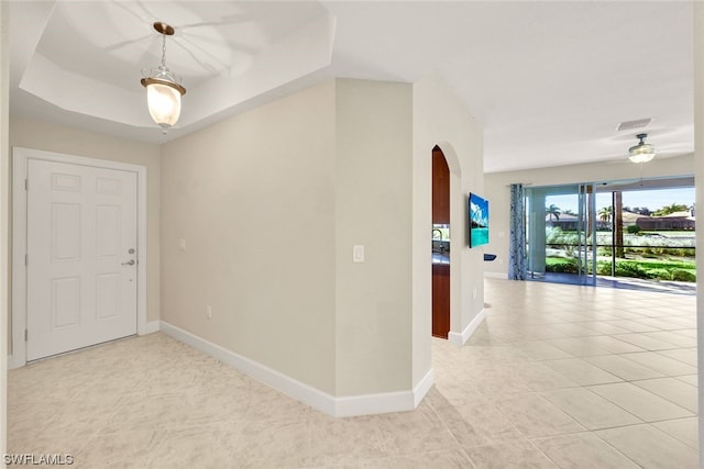 tiled entryway with a raised ceiling