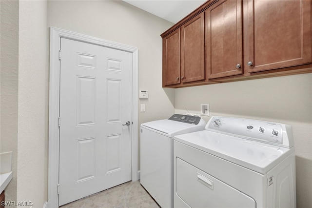 laundry area featuring cabinets, washing machine and clothes dryer, and light tile patterned flooring