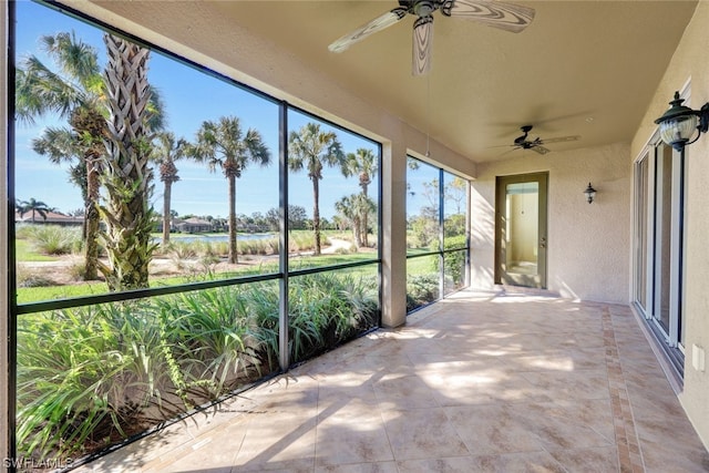 unfurnished sunroom featuring ceiling fan