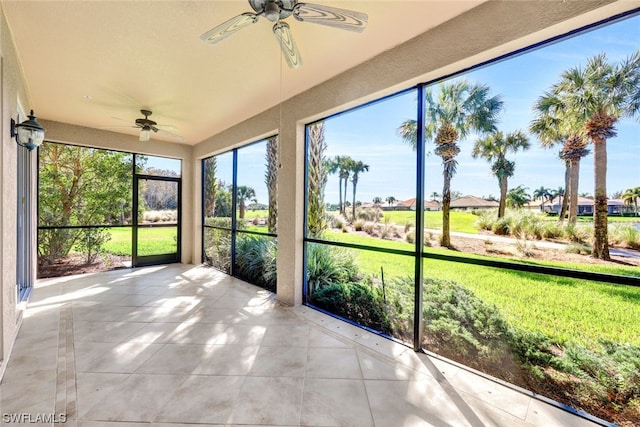 unfurnished sunroom with ceiling fan