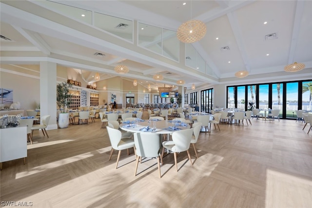 dining room with beam ceiling and high vaulted ceiling