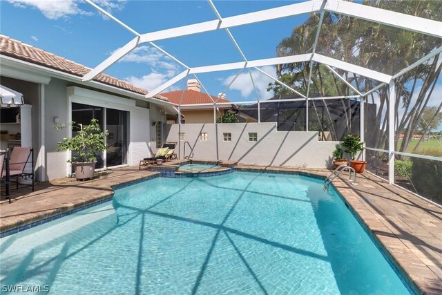 view of swimming pool featuring an in ground hot tub, a patio, and glass enclosure