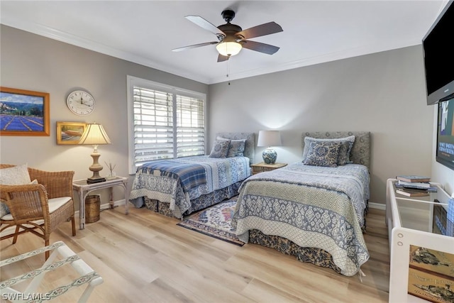 bedroom featuring hardwood / wood-style flooring, ornamental molding, and ceiling fan