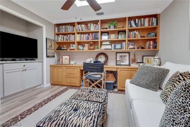 office area featuring light hardwood / wood-style flooring, built in desk, and ceiling fan