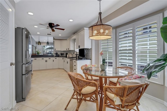 kitchen featuring pendant lighting, sink, white cabinets, and appliances with stainless steel finishes