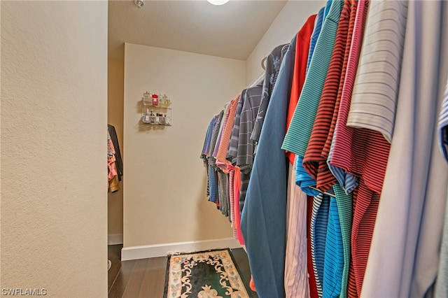 spacious closet with dark hardwood / wood-style flooring