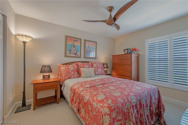 bedroom featuring light carpet, ceiling fan, and multiple windows