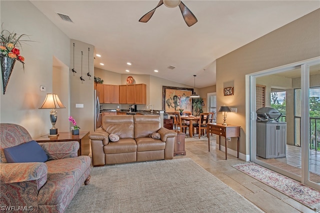 living room with light tile floors, ceiling fan, and vaulted ceiling