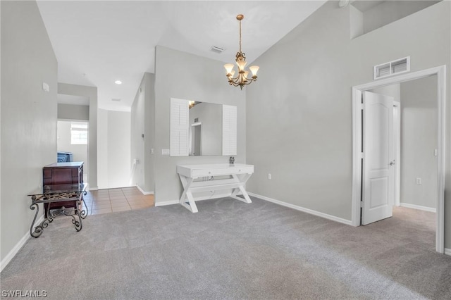 interior space featuring an inviting chandelier, vaulted ceiling, and light colored carpet