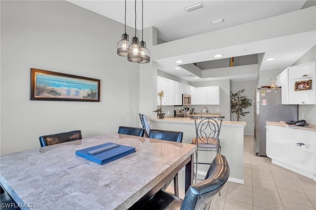 dining space featuring sink and light tile patterned floors