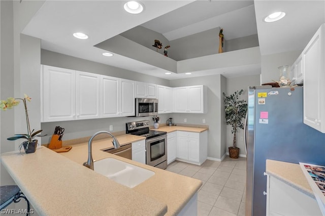 kitchen with white cabinetry, sink, kitchen peninsula, and appliances with stainless steel finishes