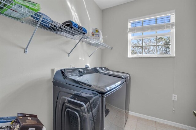 clothes washing area with light tile patterned floors and independent washer and dryer