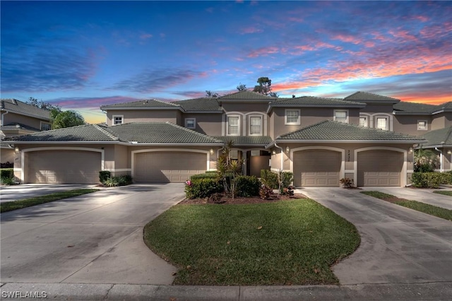 view of front of property with a garage and a lawn