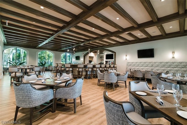 dining area with coffered ceiling, light hardwood / wood-style floors, and beamed ceiling