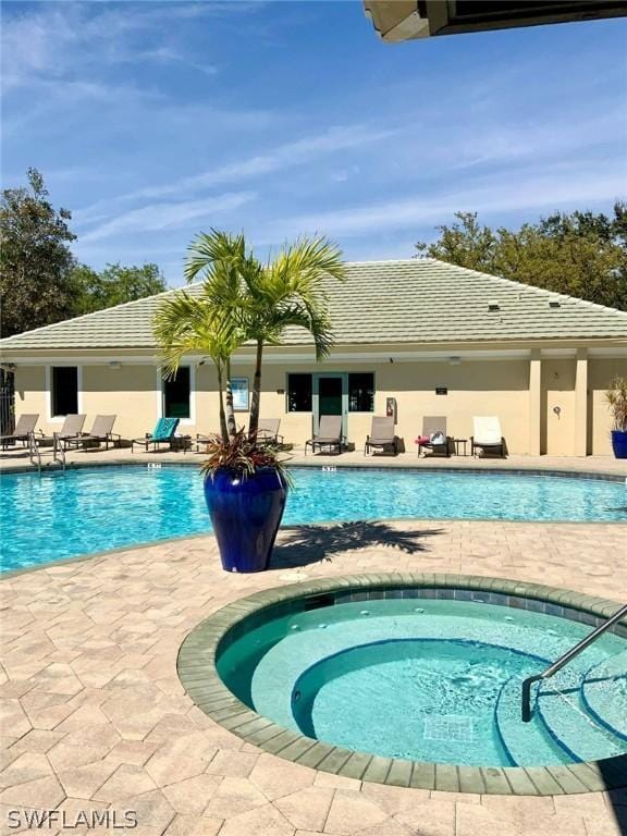 view of pool featuring an in ground hot tub and a patio