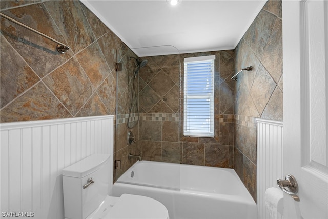 bathroom featuring tiled shower / bath combo and toilet