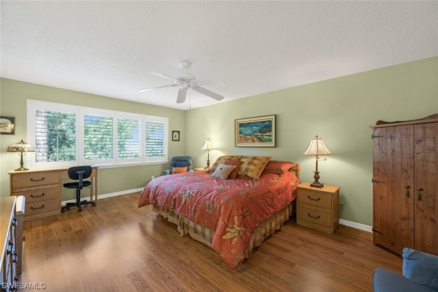 bedroom with ceiling fan, dark hardwood / wood-style floors, and a textured ceiling