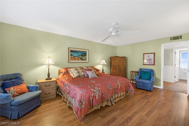 bedroom with hardwood / wood-style floors, ceiling fan, and ensuite bathroom