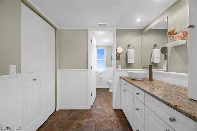 bathroom featuring ornamental molding, toilet, vanity with extensive cabinet space, and tile flooring