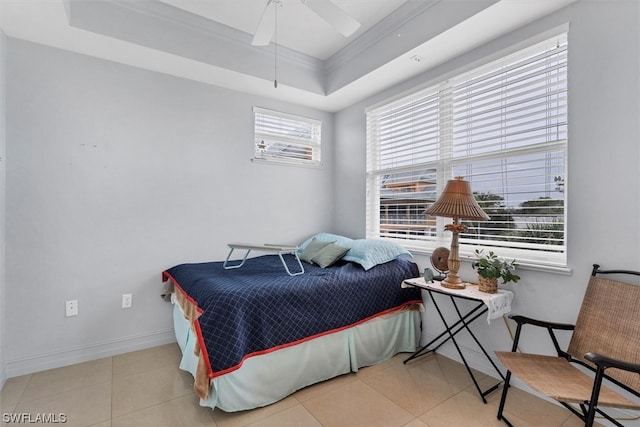 bedroom featuring light tile flooring, ceiling fan, and a tray ceiling