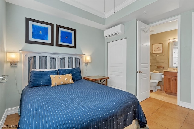 tiled bedroom featuring a raised ceiling, connected bathroom, and an AC wall unit