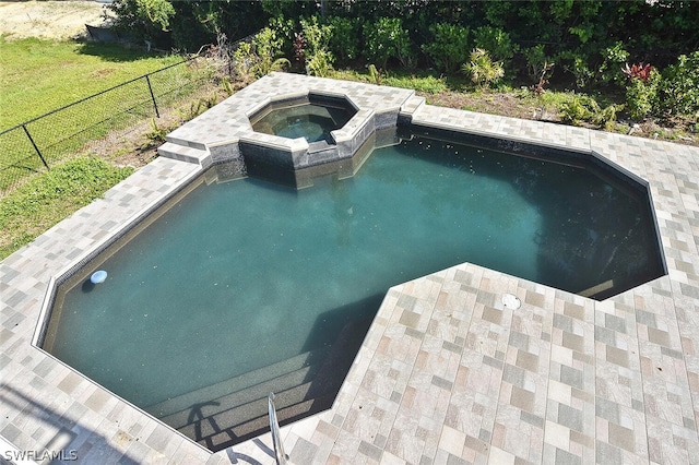 outdoor pool with fence and an in ground hot tub