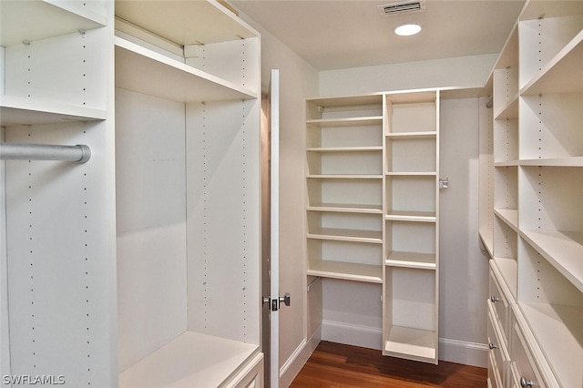 spacious closet with dark wood finished floors and visible vents