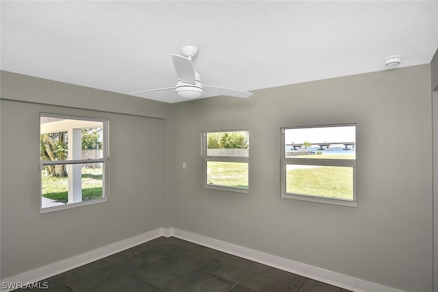 unfurnished room featuring a ceiling fan and baseboards