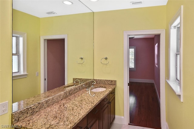 bathroom with baseboards, visible vents, and vanity