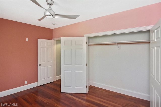 unfurnished bedroom with dark wood-style floors, ceiling fan, a closet, and baseboards