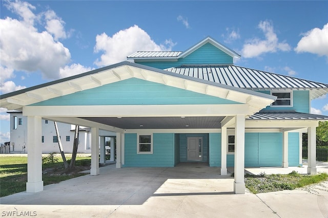 view of front of home featuring a standing seam roof, metal roof, and driveway