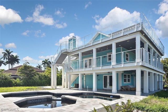 back of house with a balcony, french doors, ceiling fan, a pool with hot tub, and a patio area