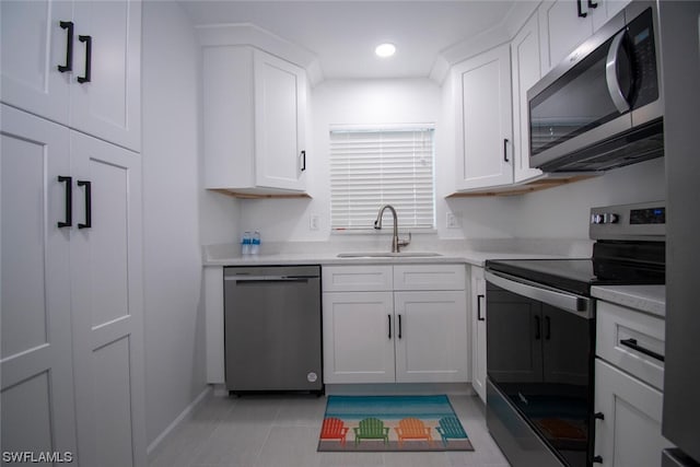 kitchen with light tile floors, white cabinetry, sink, and stainless steel appliances