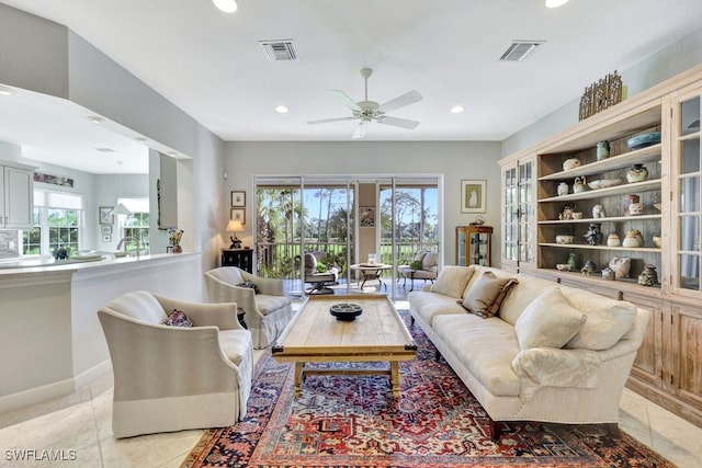 living room with ceiling fan, plenty of natural light, and light tile patterned flooring