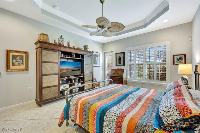 bedroom with ceiling fan, light tile patterned floors, crown molding, and a tray ceiling