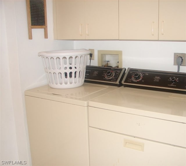 clothes washing area featuring hookup for a washing machine, cabinets, electric dryer hookup, and washing machine and dryer