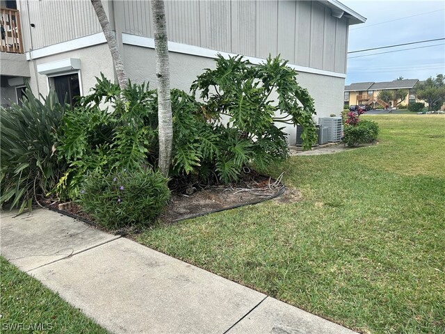 view of home's exterior featuring a yard and central AC unit