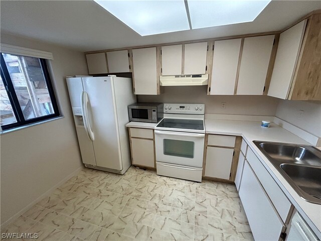 kitchen with white cabinetry, white appliances, light tile flooring, and sink