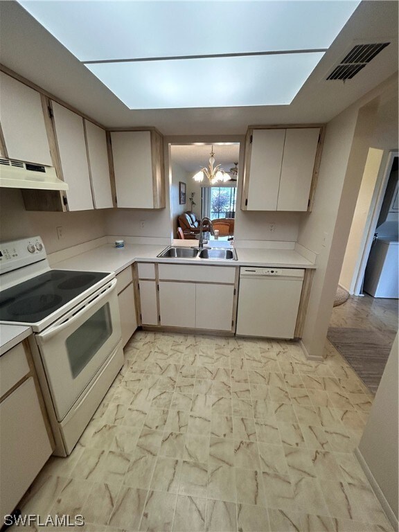 kitchen with a chandelier, light tile flooring, white appliances, and sink